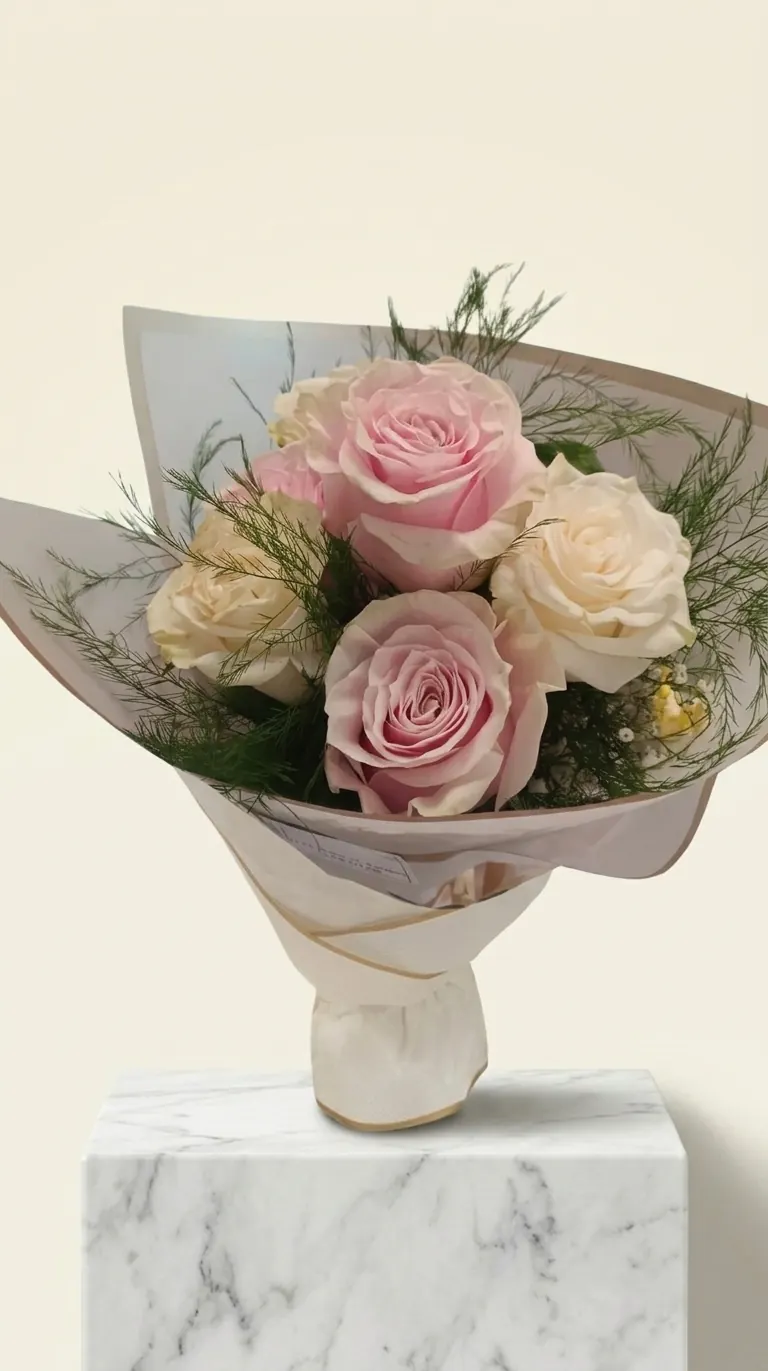 Bouquet di rose rosa e crema avvolto in carta